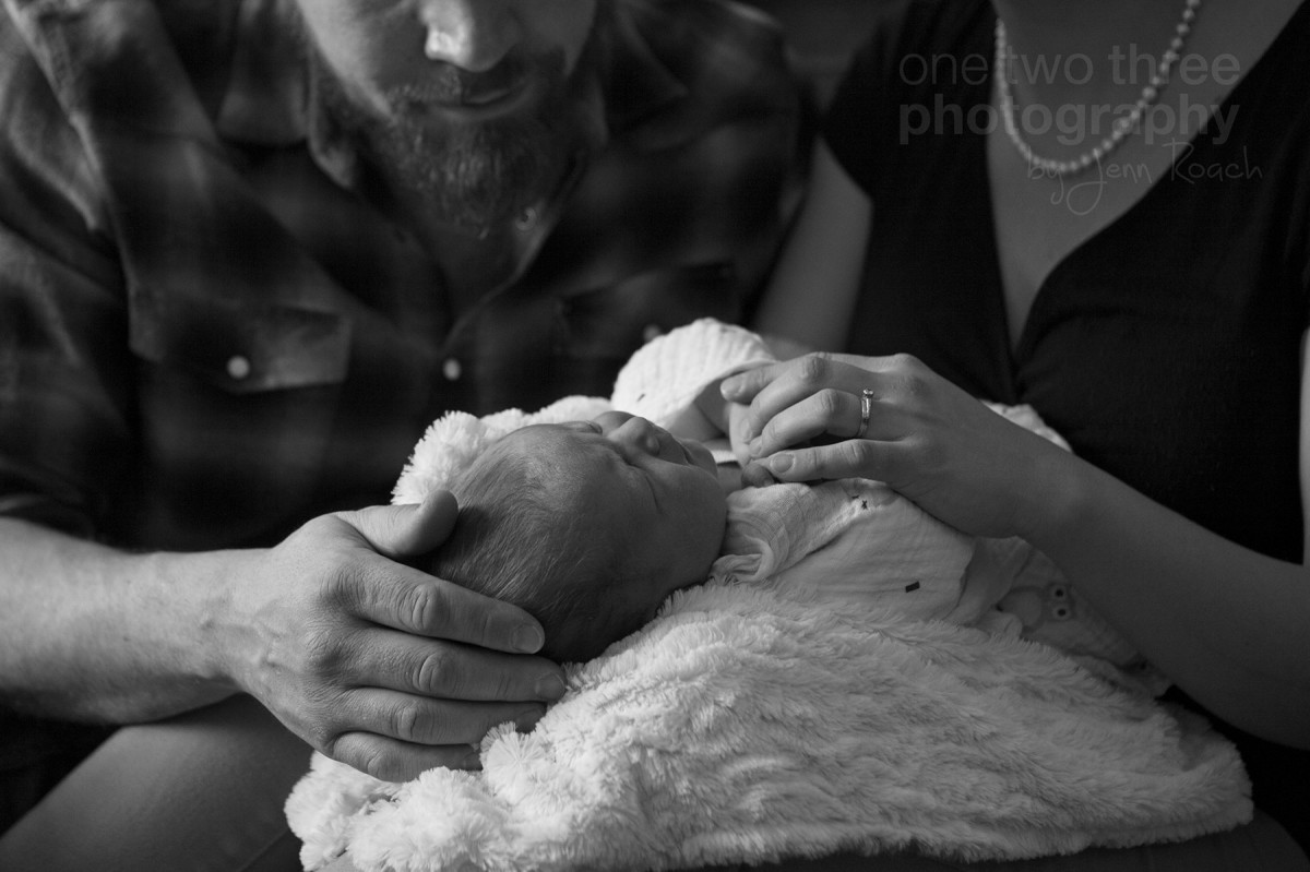 Newborn is soothed by her parents during candid newborn photography session in Calgary