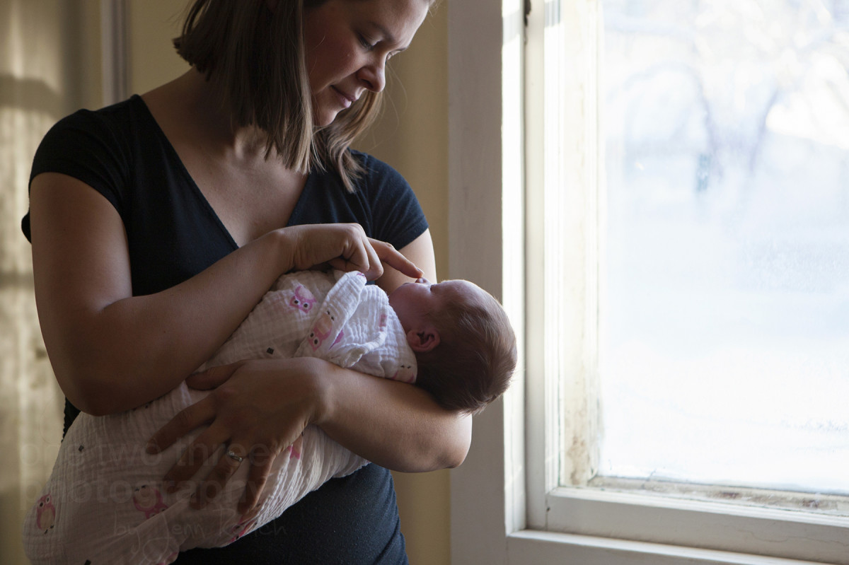 Erika holding her newborn daughter in her home in Kensington