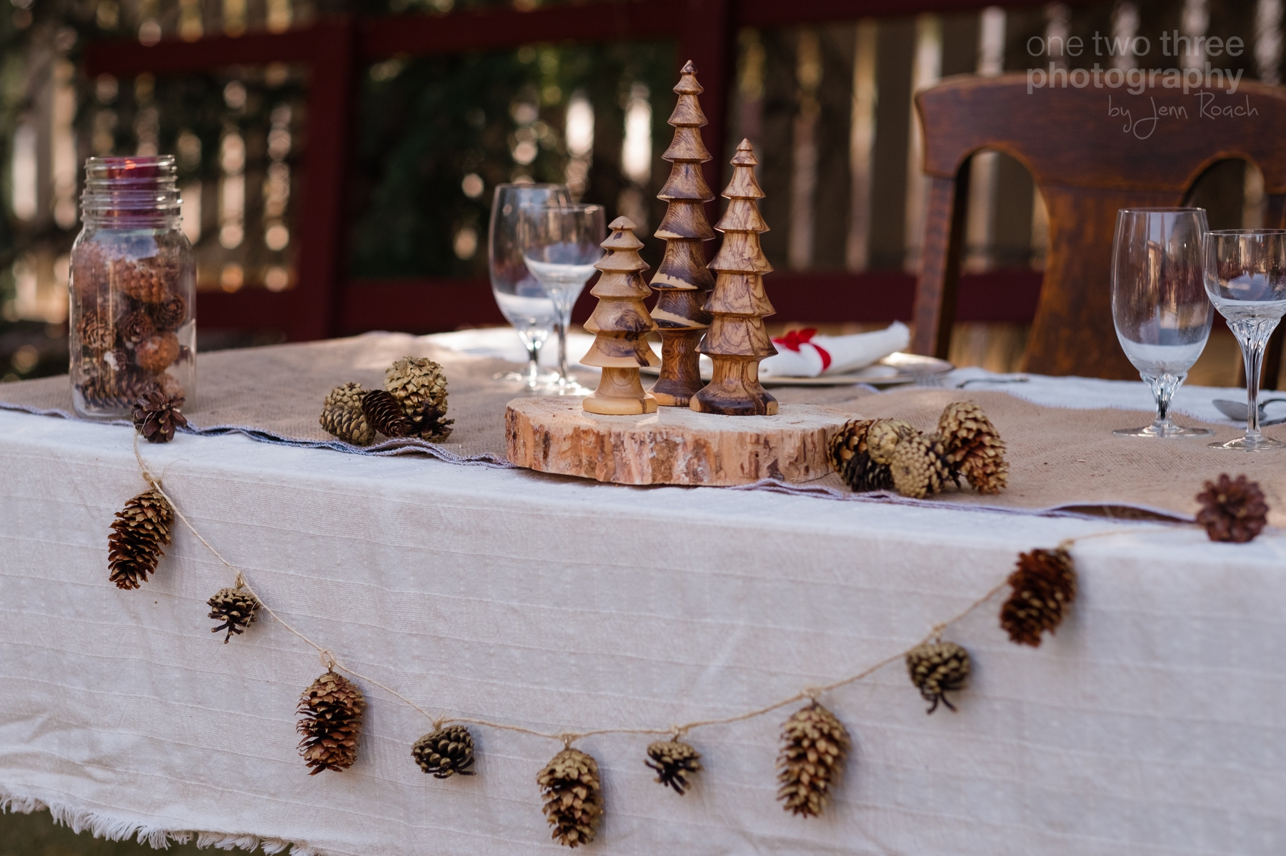 Rustic wedding table settings with pinecones and wood place settings