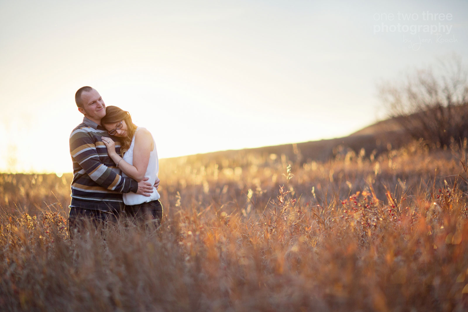 A backlit couple in a field in the fall