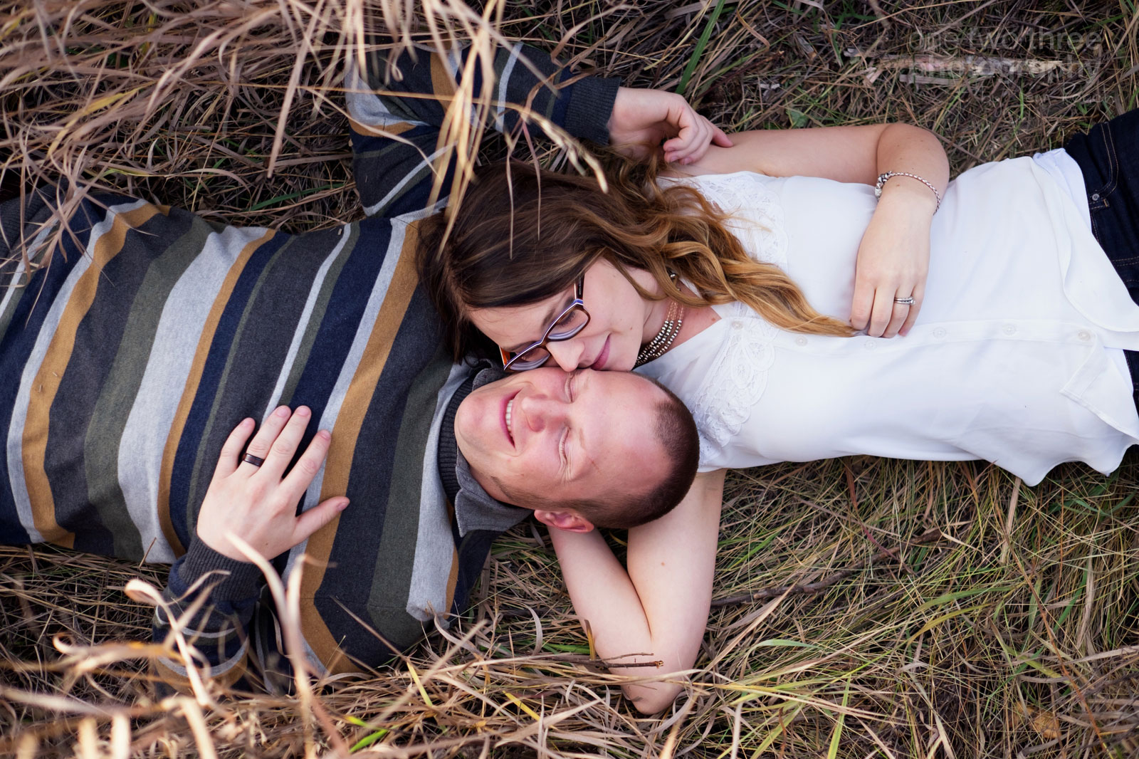 Pose example of a couple laying on their backs in tall grass